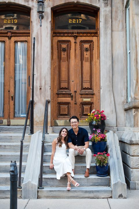 Sitting together on stone steps beneath a carved wooden door
