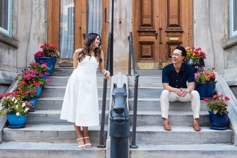 Laughing across the railing on flower-lined stone steps
